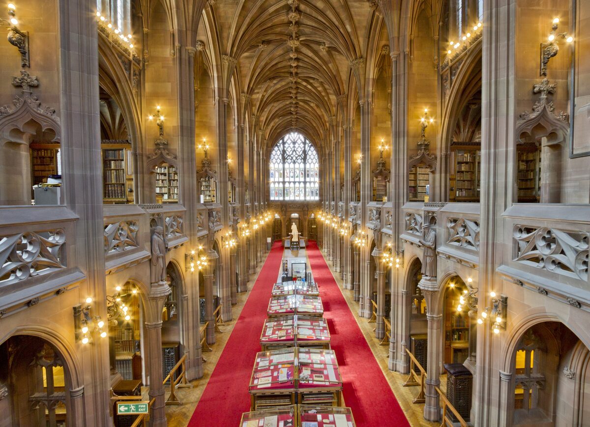 The Gothic reading room of the John Rylands Library in Manchester, with stone vaults and a red carpet