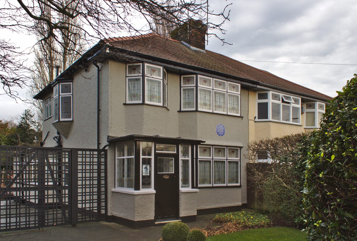 Mendips, the 1930s semi-detached house where John Lennon grew up, with a front garden and a blue plaque