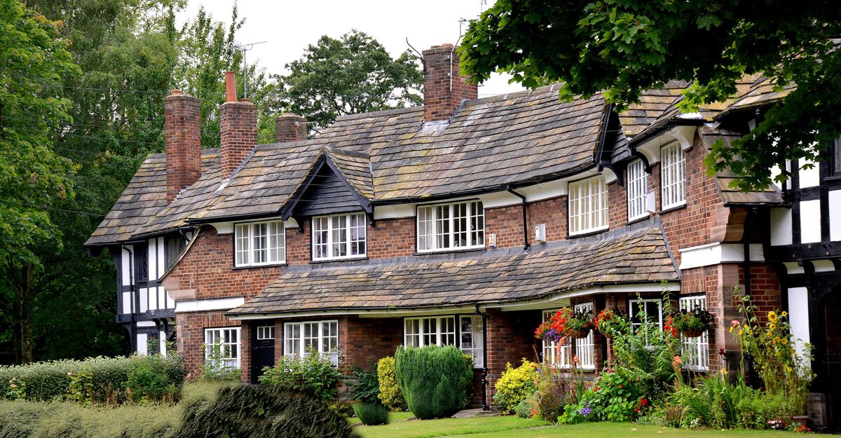 Brick and half-timbered cottages with flower beds in the model village of Port Sunlight