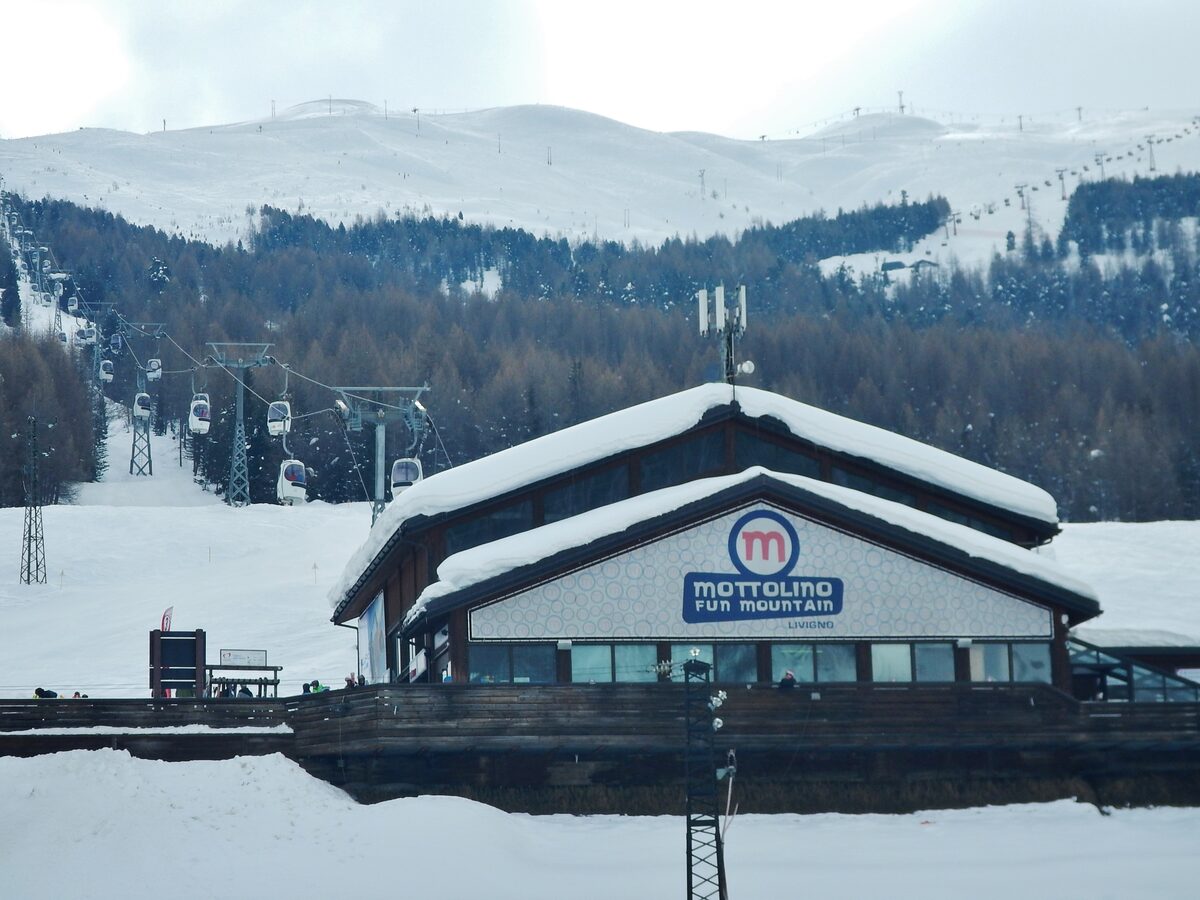 The Mottolino base station in the snow, with its ticket building and the lift lines behind it