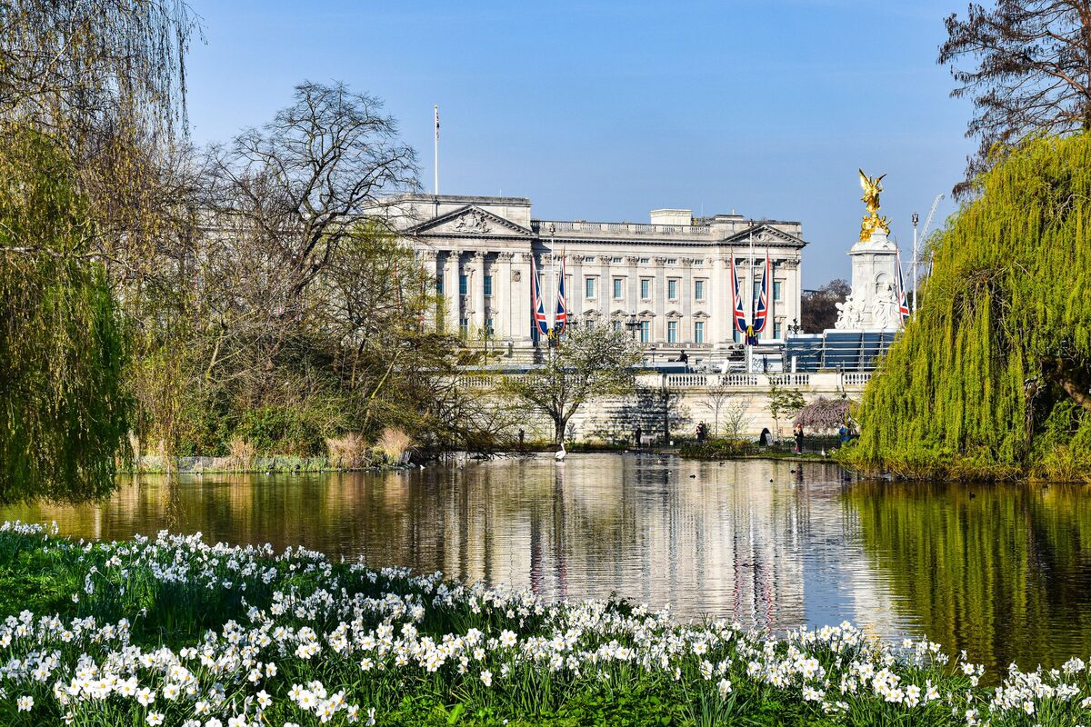 Buckingham Palace in London with its gold-gated forecourt and the Victoria Memorial in front