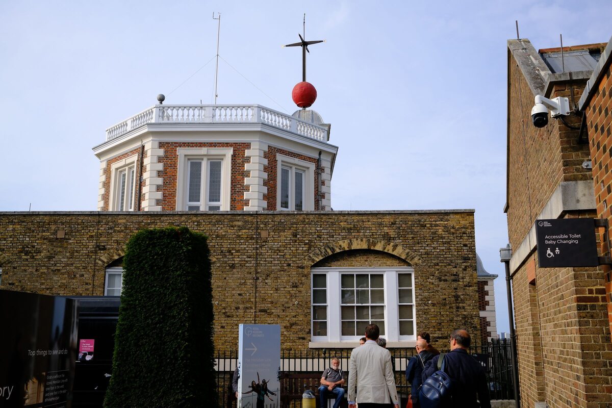 The red-brick Royal Observatory in Greenwich on a hill, with the red time ball on its roof