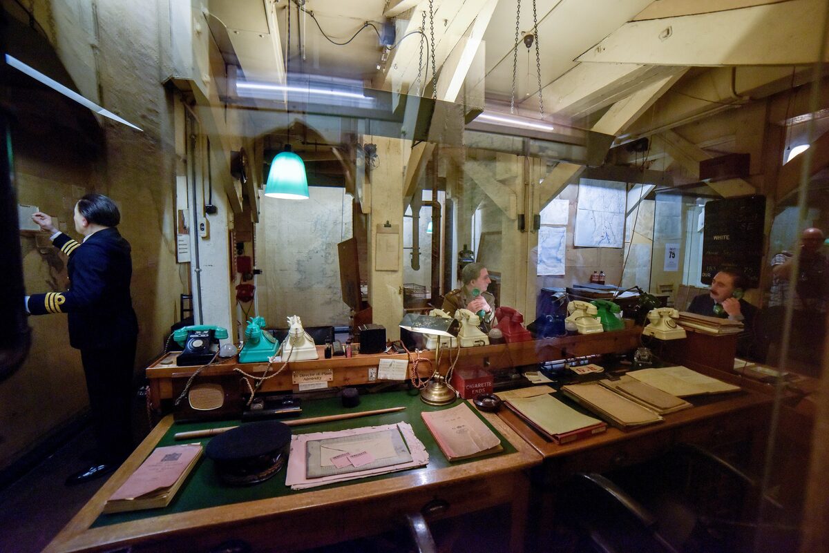 The Map Room in the Churchill War Rooms, with wall maps, colored telephones and desks left as they were in 1945
