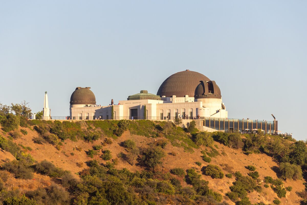 Griffith Observatory with its copper domes on a dry hilltop in Griffith Park in warm evening light
