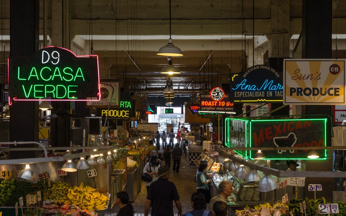 Neon signs and produce and taco stalls inside Grand Central Market in Downtown Los Angeles