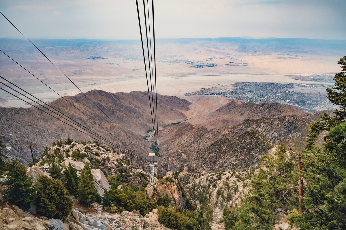 The Palm Springs Aerial Tramway cables dropping from the rocky San Jacinto slope to the desert valley below