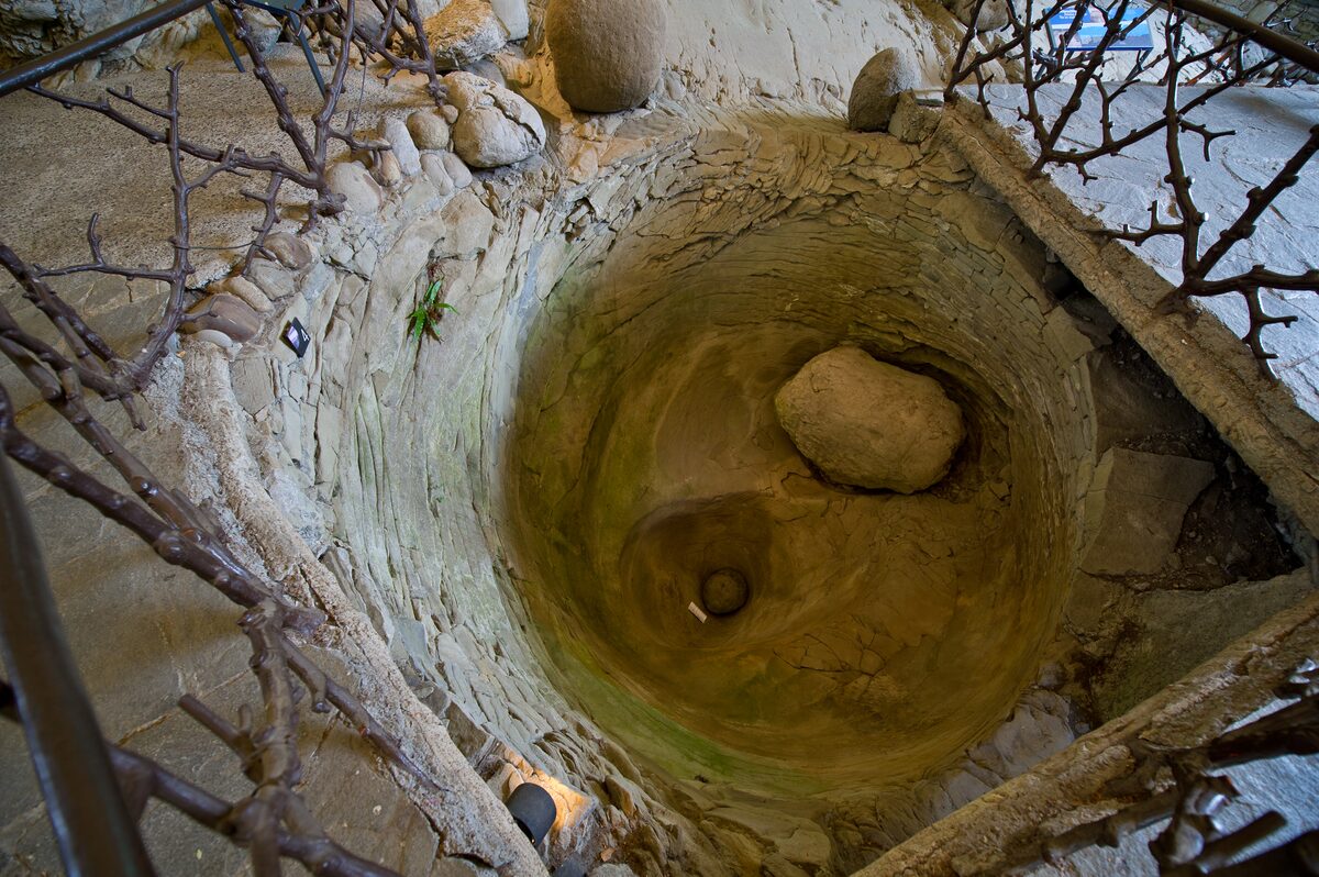 A glacier pothole, a round hollow ground into the rock by meltwater, in the Glacier Garden