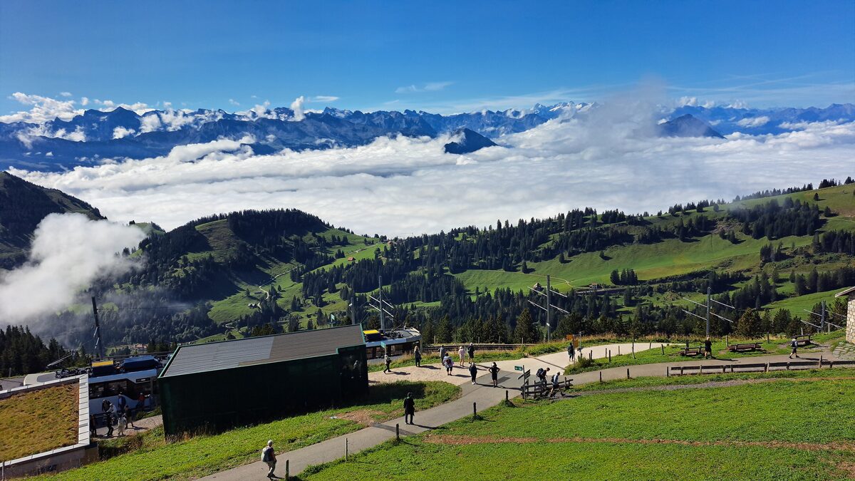 The Rigi Kulm summit area with its buildings and paths, a sea of cloud and snowy Alps behind