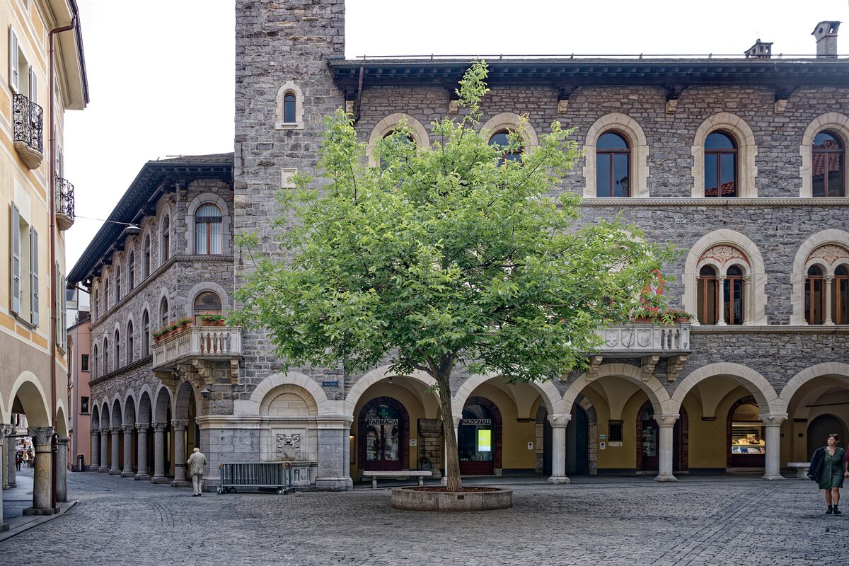 The arcaded stone town hall on Piazza Nosetto in Bellinzona, one of the squares the Saturday market fills