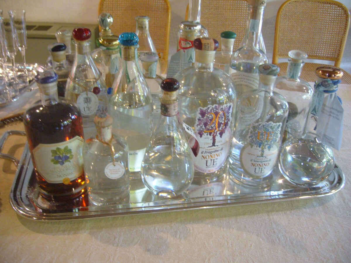 A silver tray of grappa bottles in different shapes, from clear spirits to an amber one