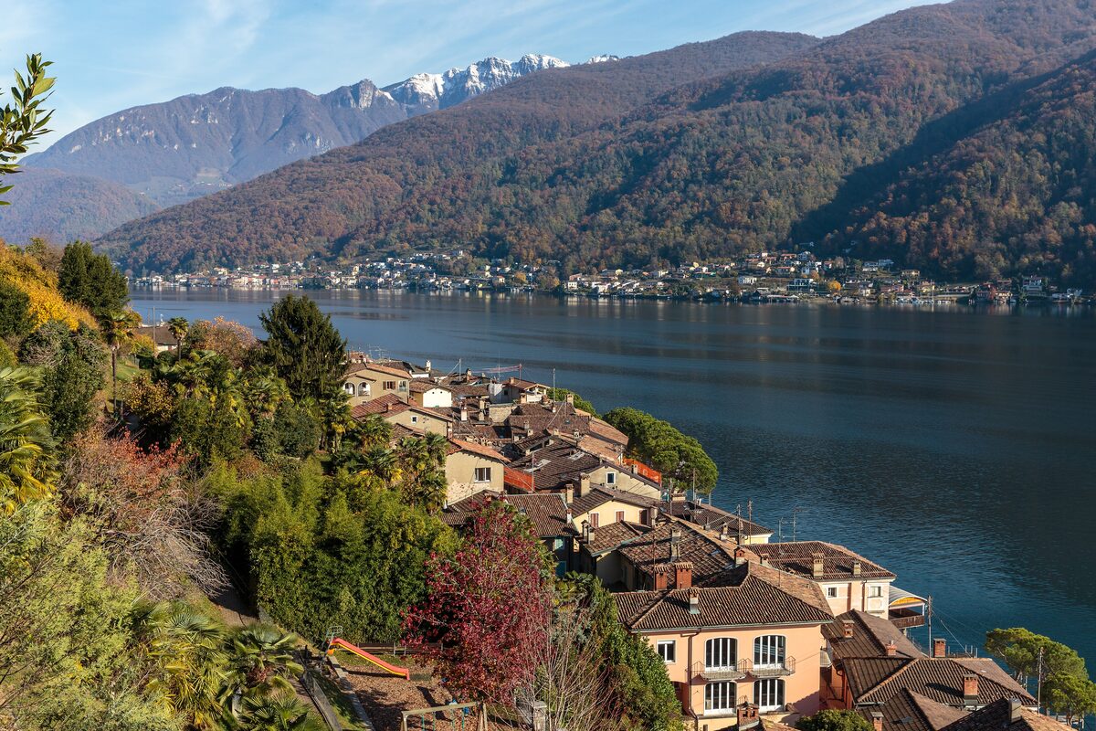Morcote's old roofs on the lakeshore, with the lake and wooded hills behind the village