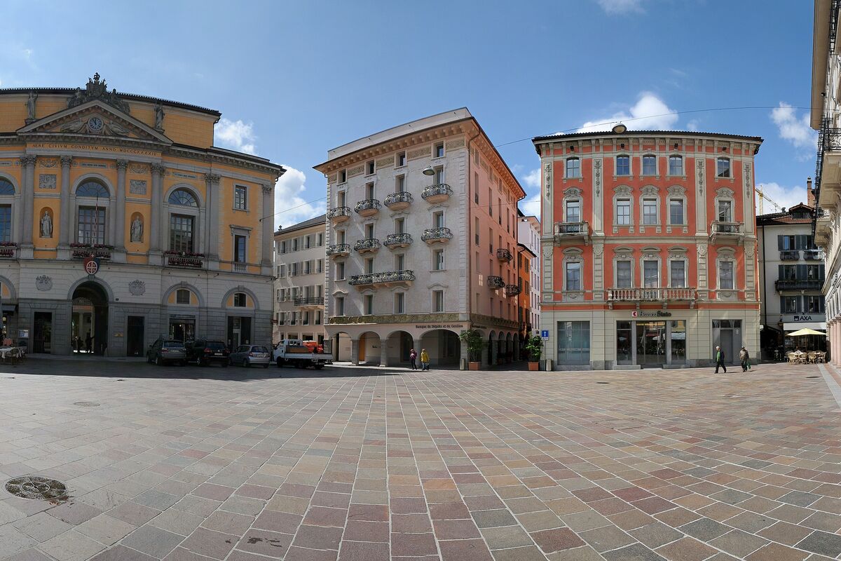 The ochre town hall and pink palazzi around Piazza della Riforma, with the square's paving in the foreground