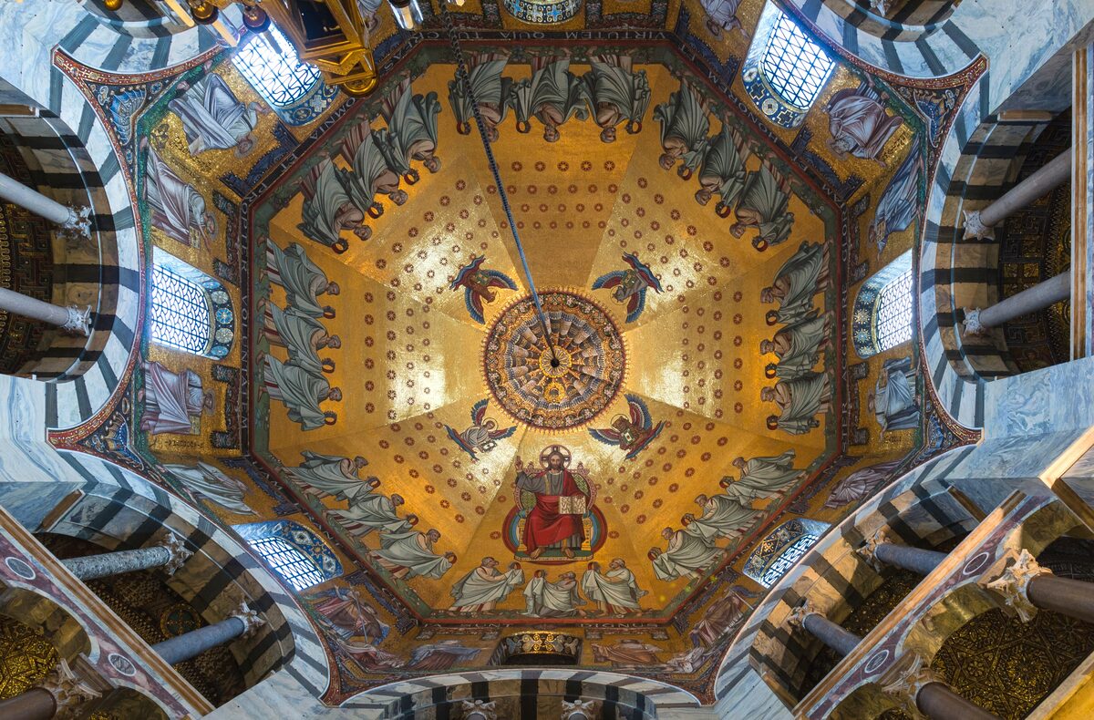 The golden mosaic of the octagonal dome of Aachen Cathedral, with Christ enthroned in the center and figures around him