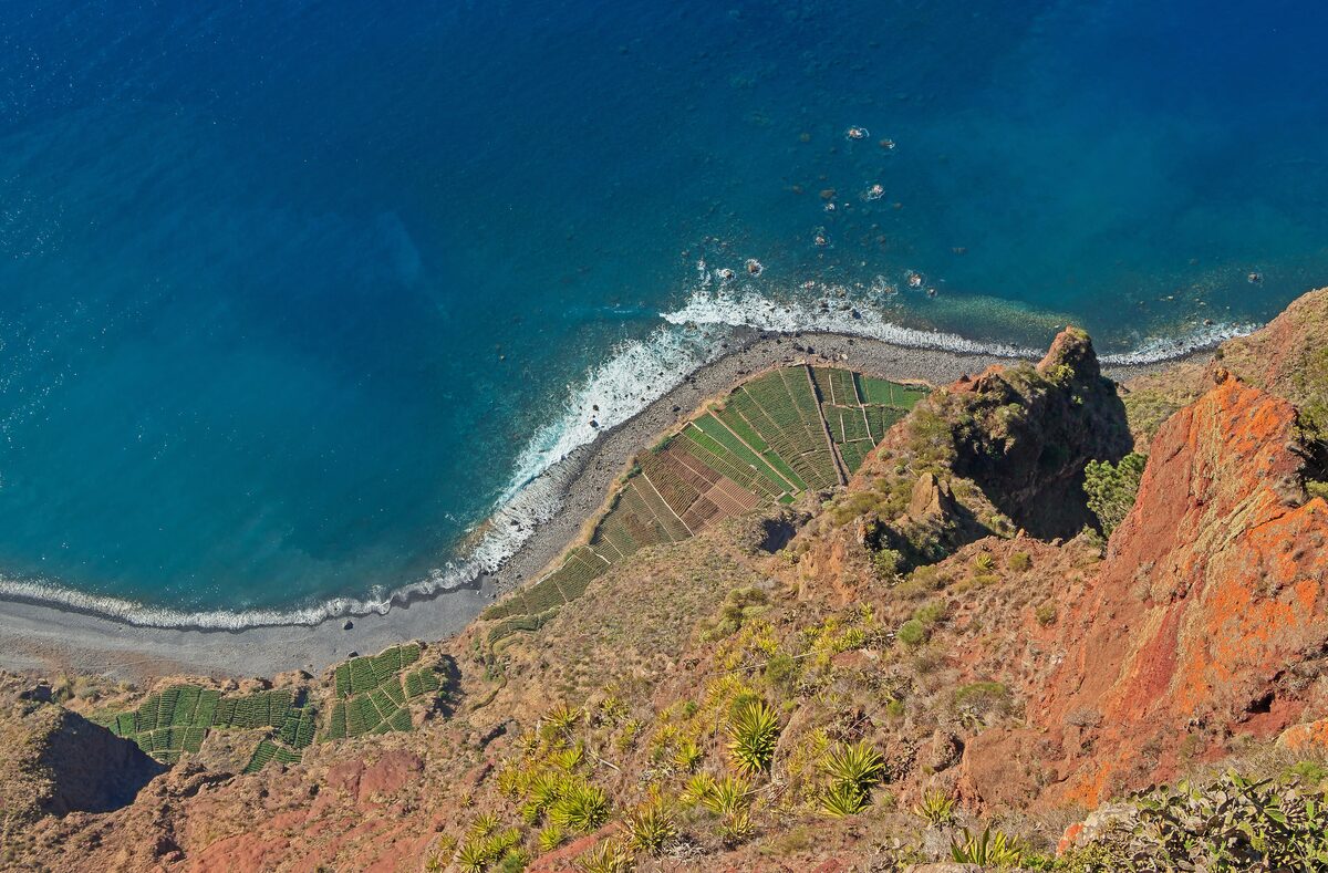 Looking down from the Cabo Girão cliff top to the sea and terraced fields far below
