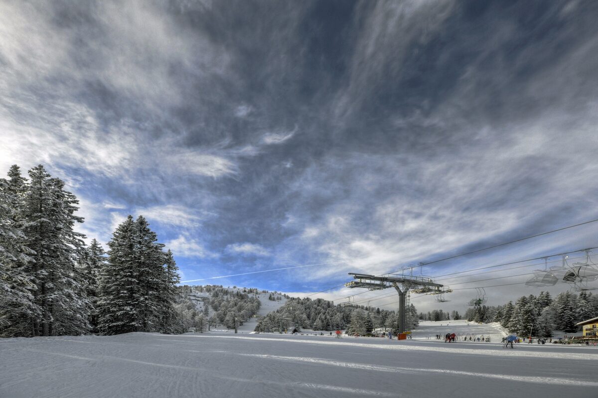 A chairlift running over snowy slopes at Malghet Haut in Folgarida, under a cloudy winter sky