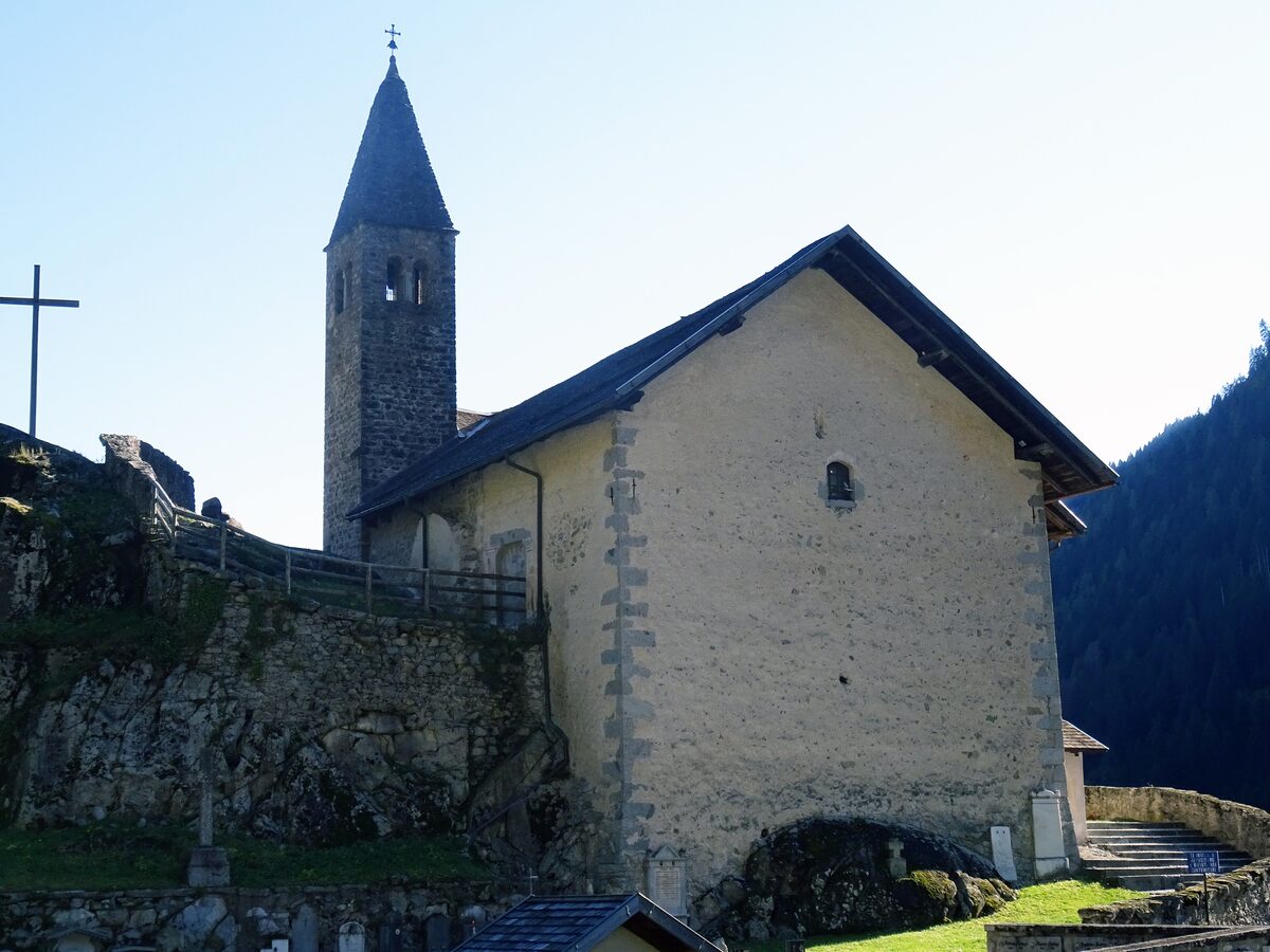 The church of Santo Stefano in Carisolo, with its tall bell tower and stone walls under a pale sky