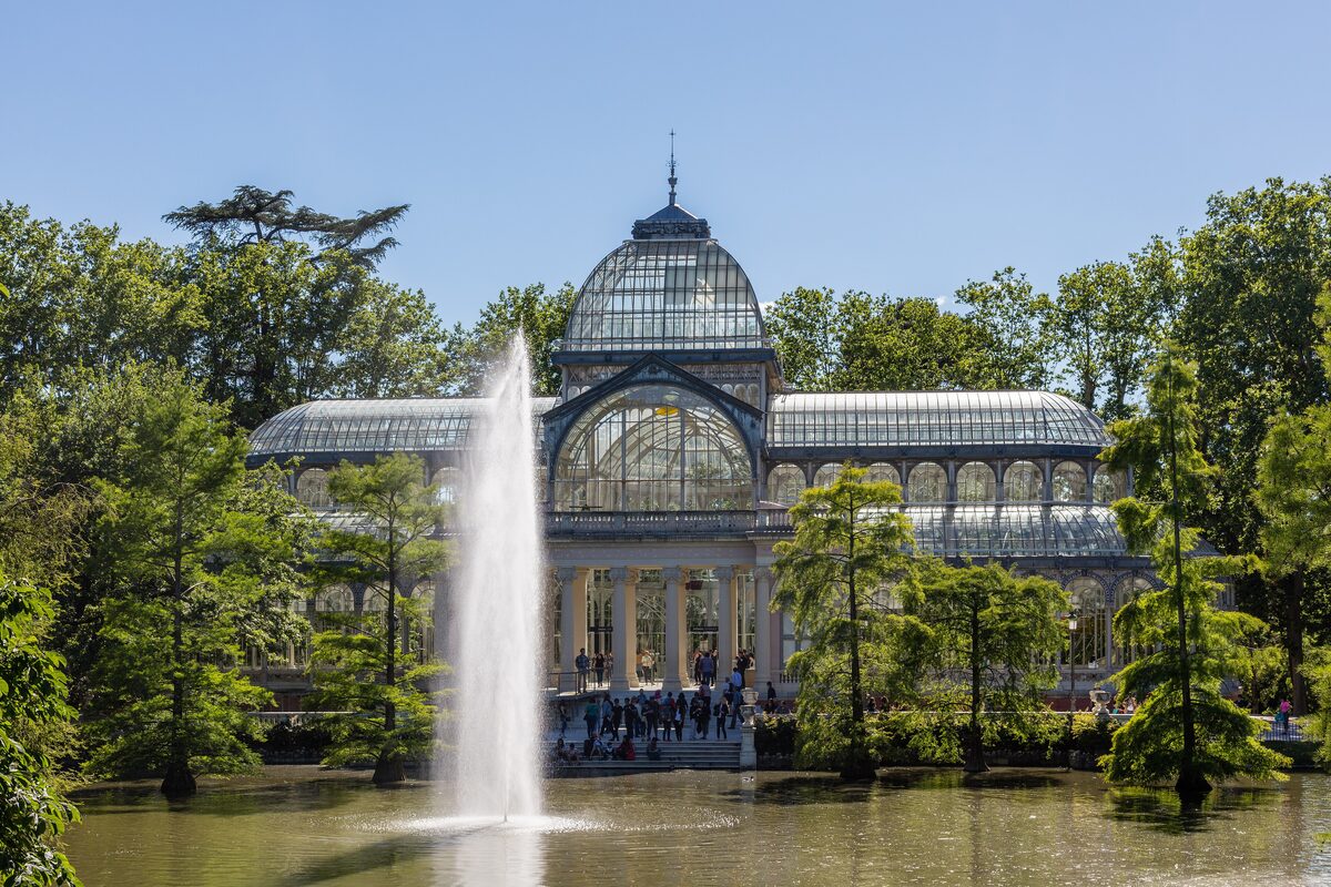 The glass-and-iron Palacio de Cristal and its fountain on the lake in Retiro Park