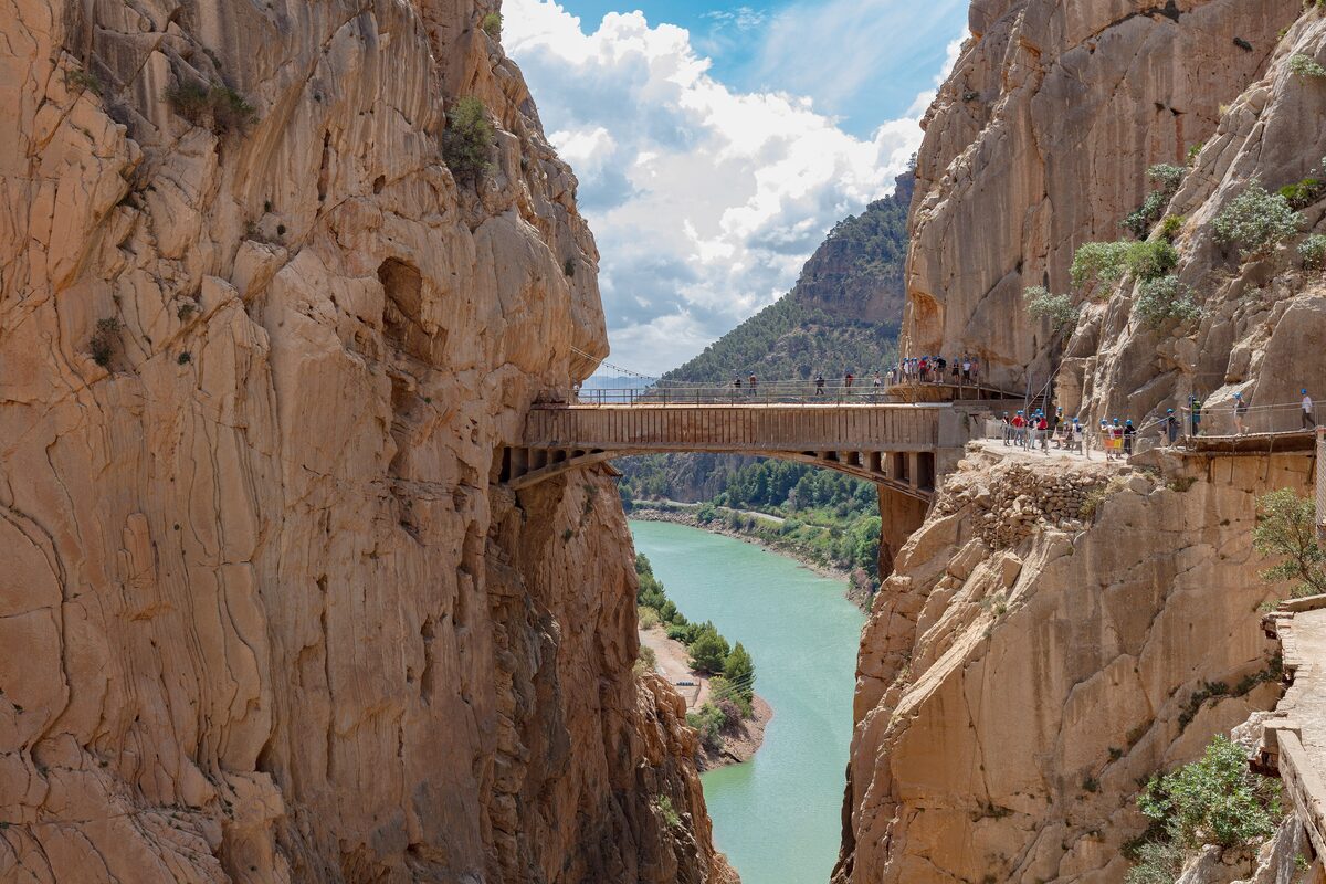 The Caminito del Rey walkway on the cliff, with a bridge ahead and the river far below