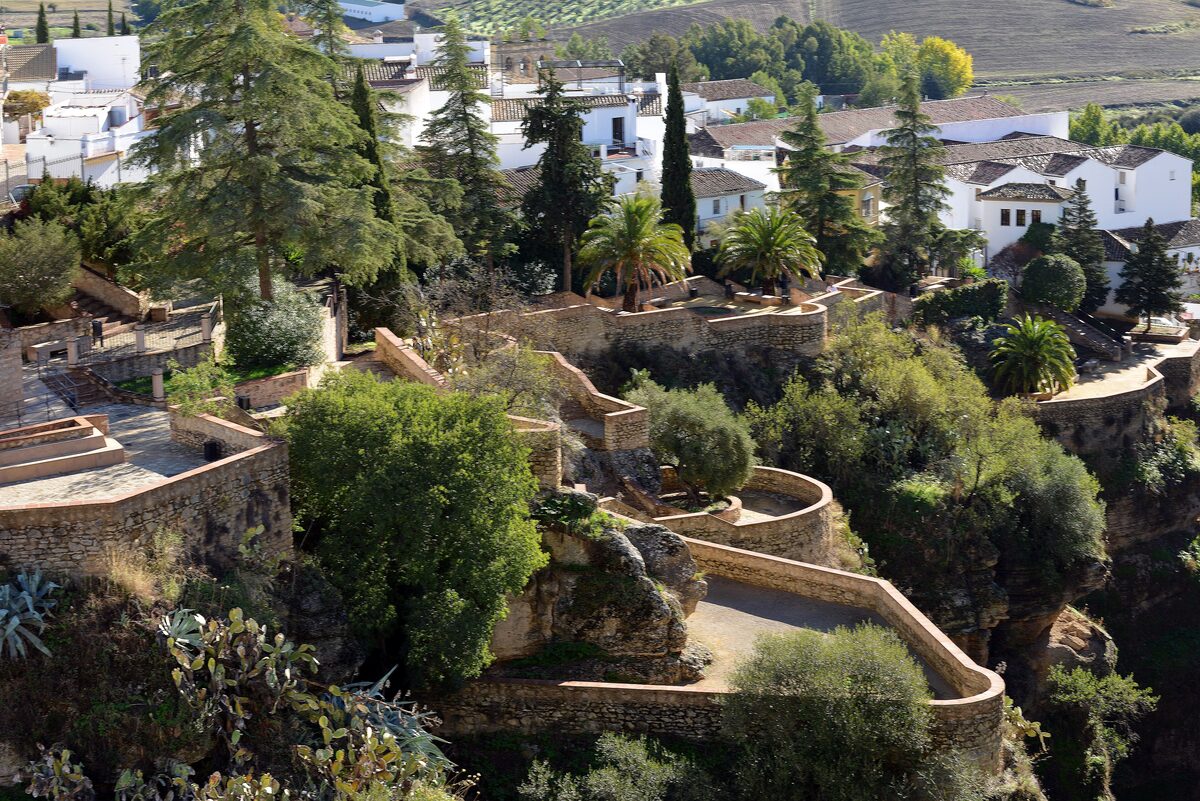 Terraced garden walls on the cliff edge above the Ronda gorge, with white houses above