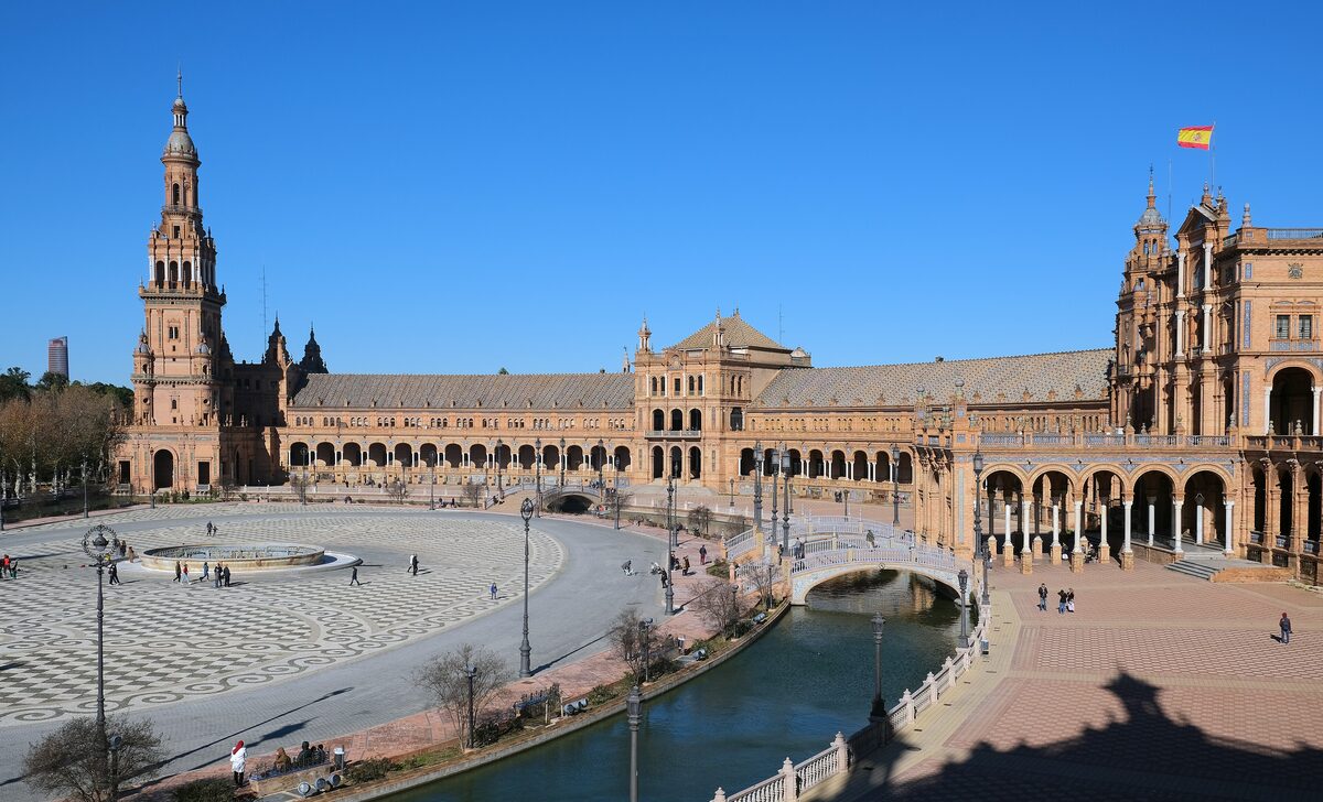 The semicircular Plaza de España in Seville, with its brick arcades, tower and canal