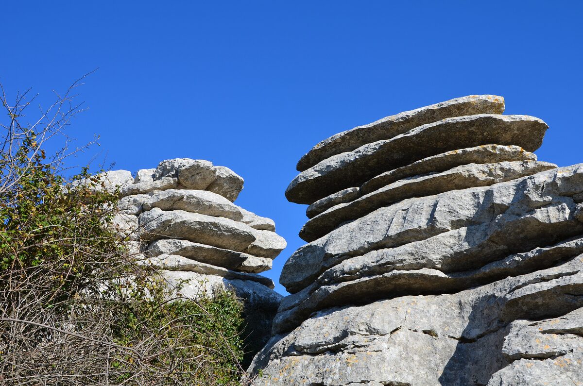 Layered limestone blocks stacked into strange shapes on El Torcal, under a clear blue sky