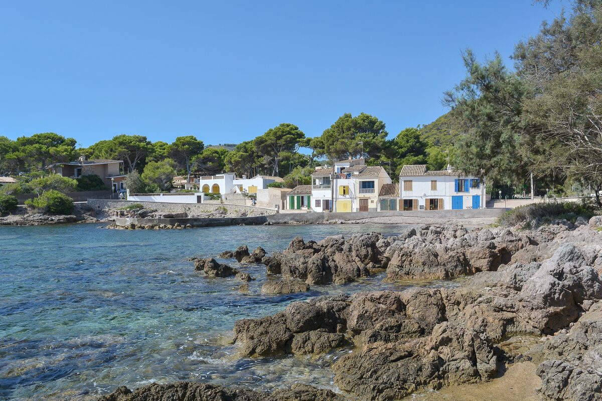 Rocky coast and the white houses of Cala Pedruscada near Cala Ratjada, with the sea in front