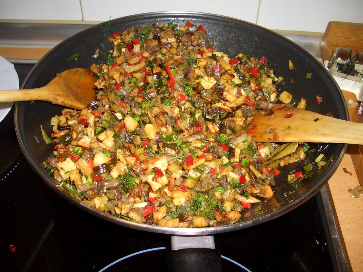 A pan of frit mallorquí, diced meat and potato fried with red and green peppers and herbs