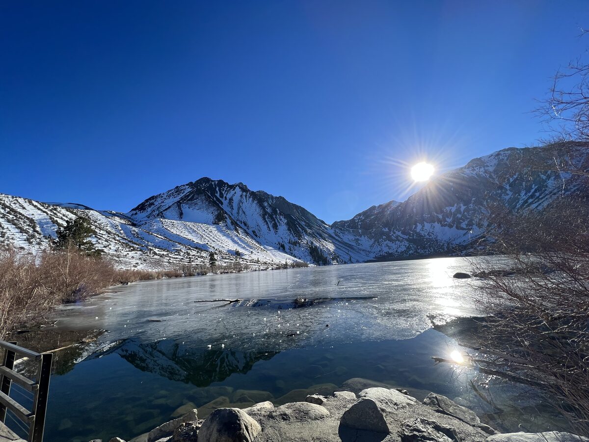 Frozen Convict Lake below snowy peaks on a clear winter morning