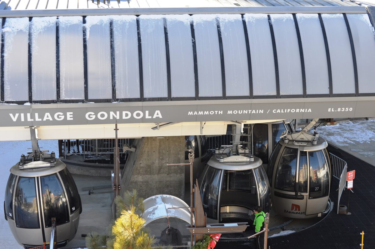 The Village Gondola station under a snow-laden roof, with cabins waiting