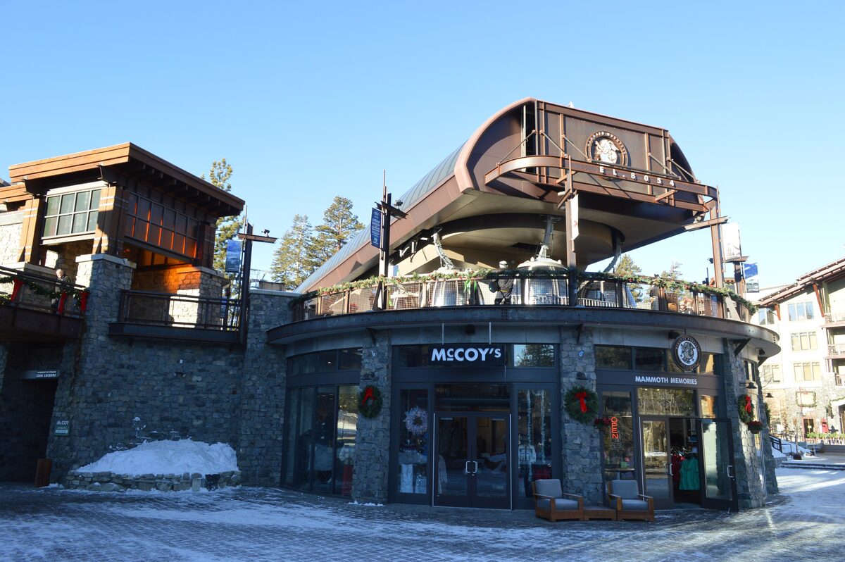 Snowy Village plaza with shopfronts below the Village Gondola station