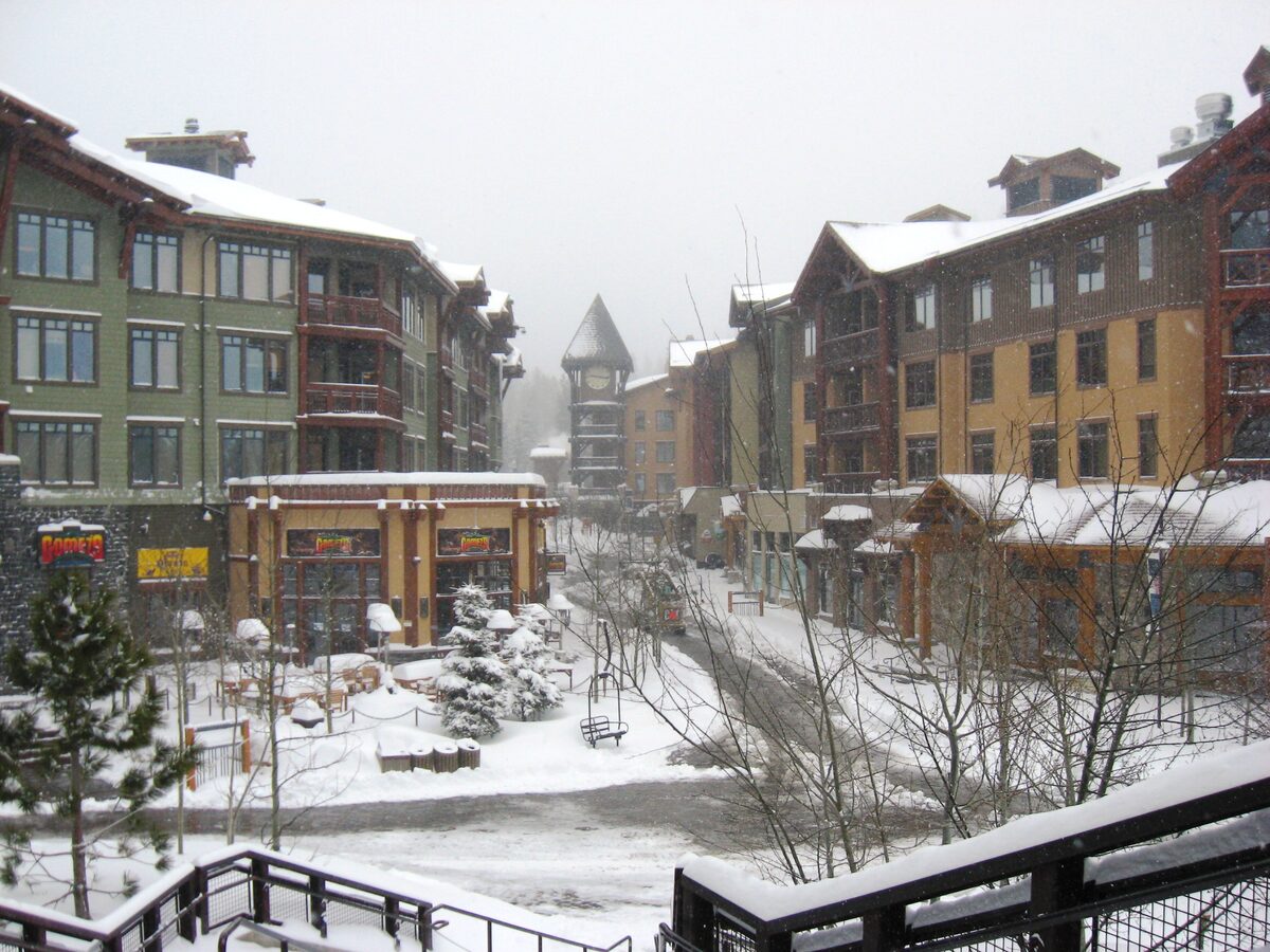 Snow-dusted lodging buildings and a clock tower in the Village at Mammoth