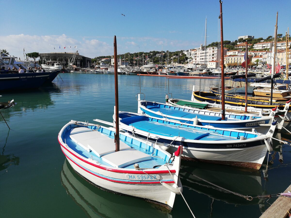 Traditional wooden fishing boats moored in the harbor of Cassis, with the waterfront houses behind
