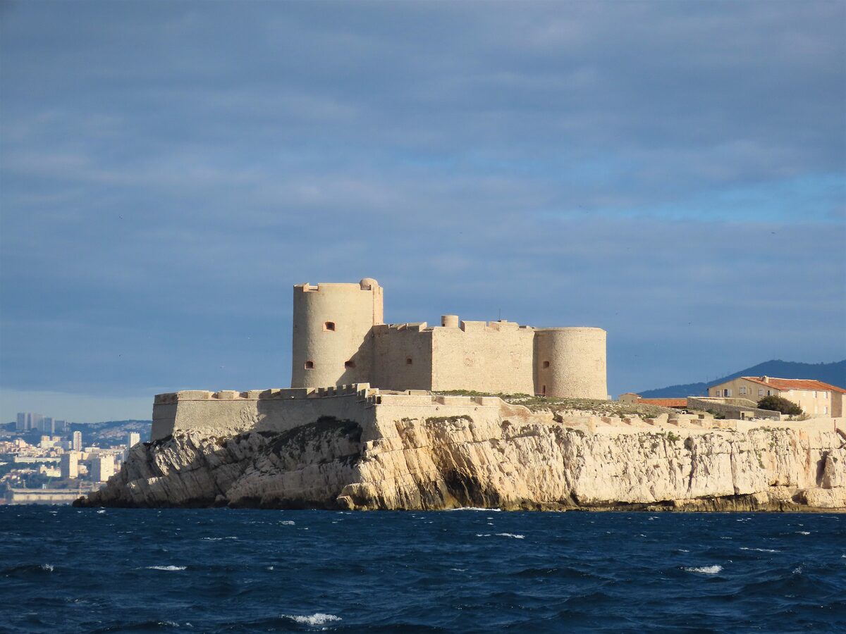 The Château d'If, its round towers and walls rising from a limestone rock above the blue water