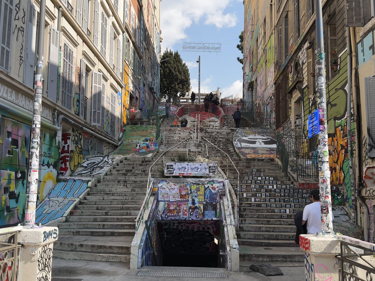 The Cours Julien stairs, covered in graffiti and street art, climbing between the tall buildings