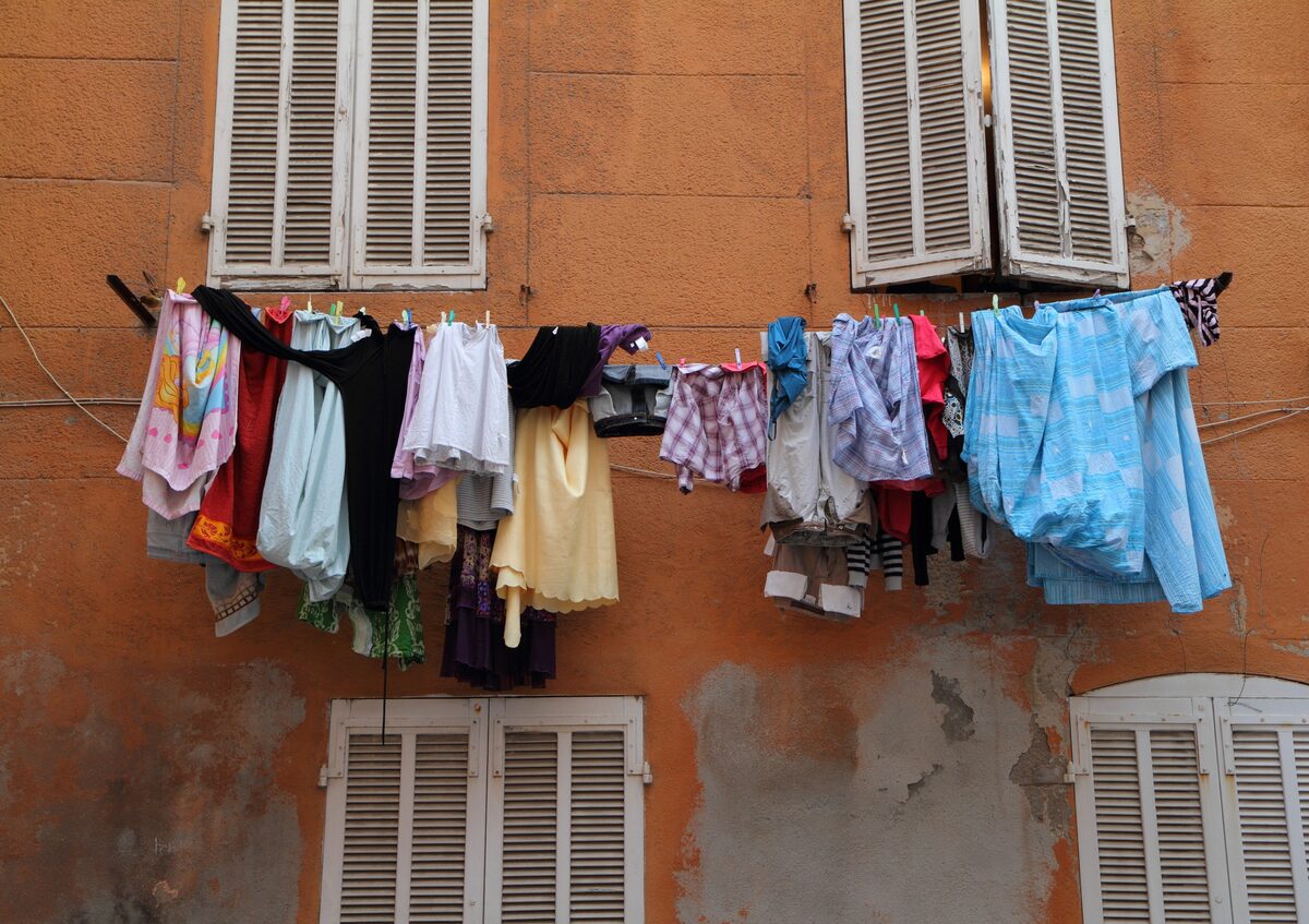 Laundry hung out to dry on the shutters of an orange wall in Le Panier