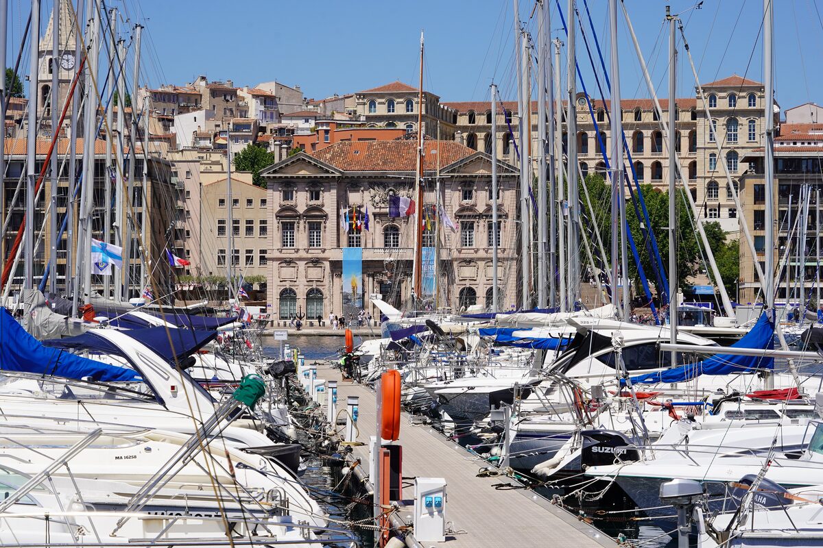 Yachts moored along the Old Port, with the grand stone facades of the quays rising behind them