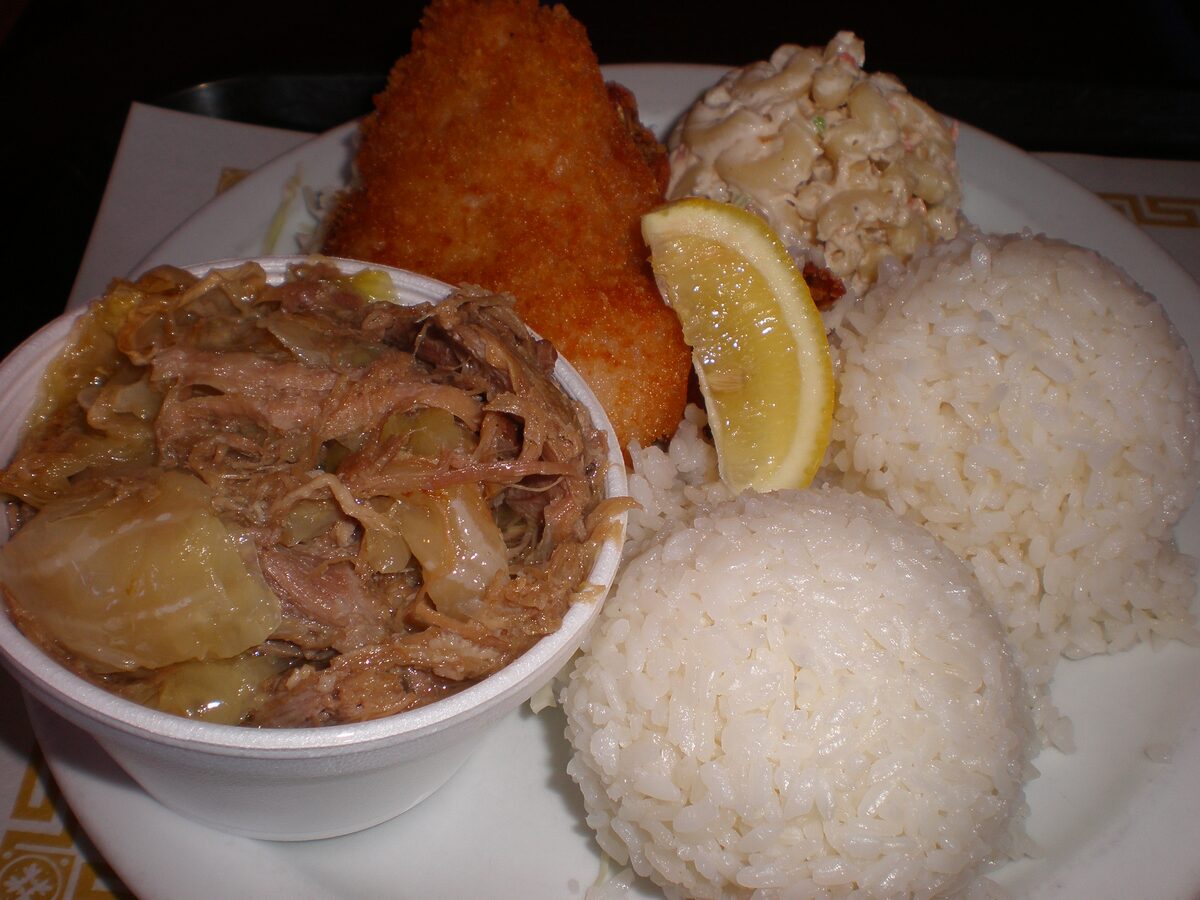 A Hawaiian plate with shredded kalua pork, rice, macaroni salad and fried fish