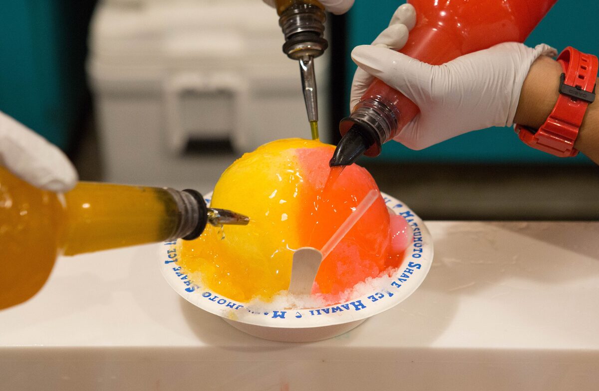 Orange and red syrup poured over a mound of shave ice