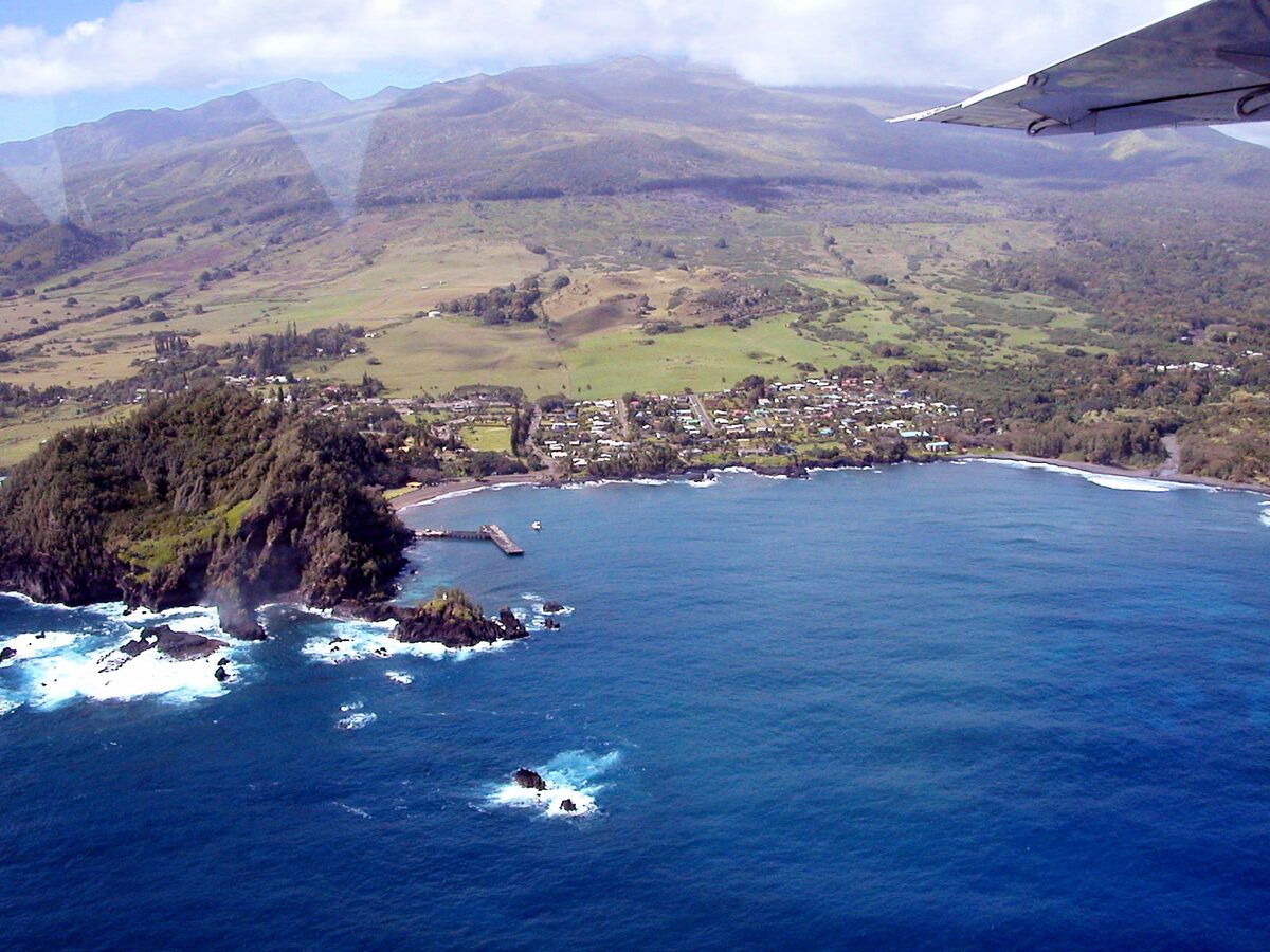 Aerial view of Hāna and its bay, with green slopes of Haleakalā behind
