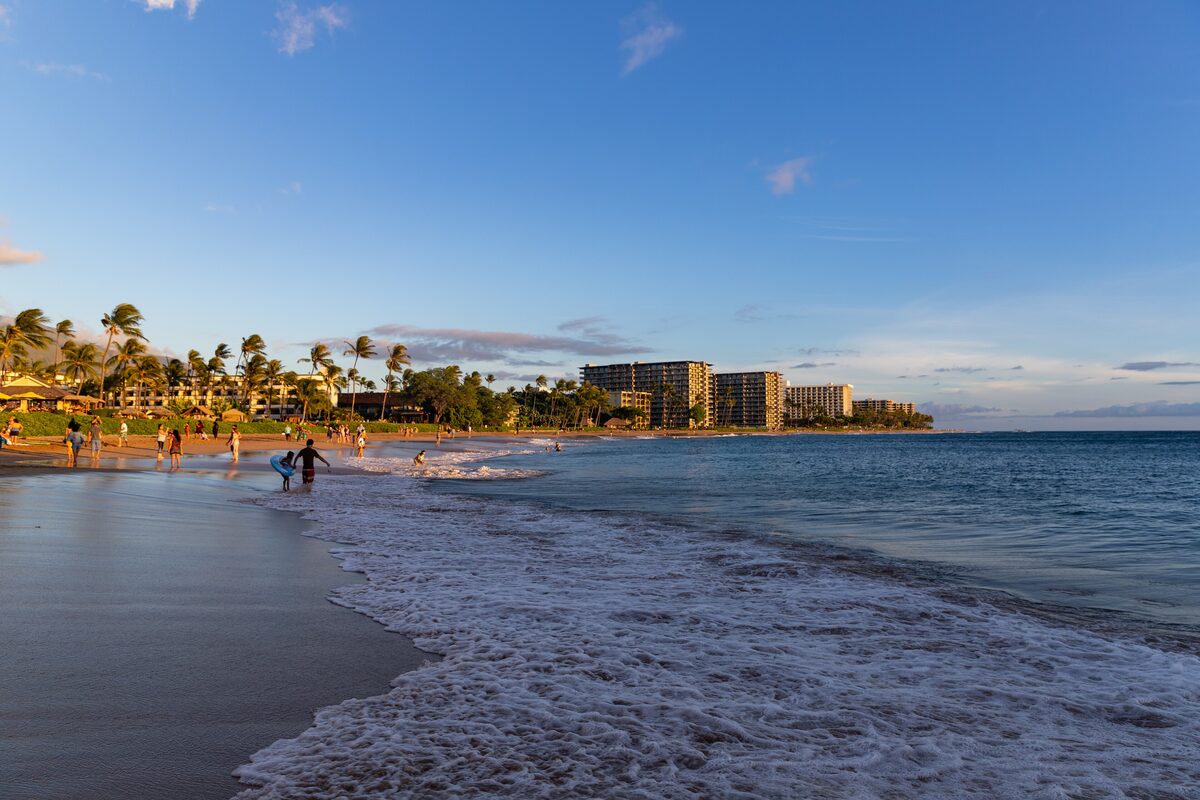 Surf washing the sand of Kāʻanapali Beach with resorts along the shore