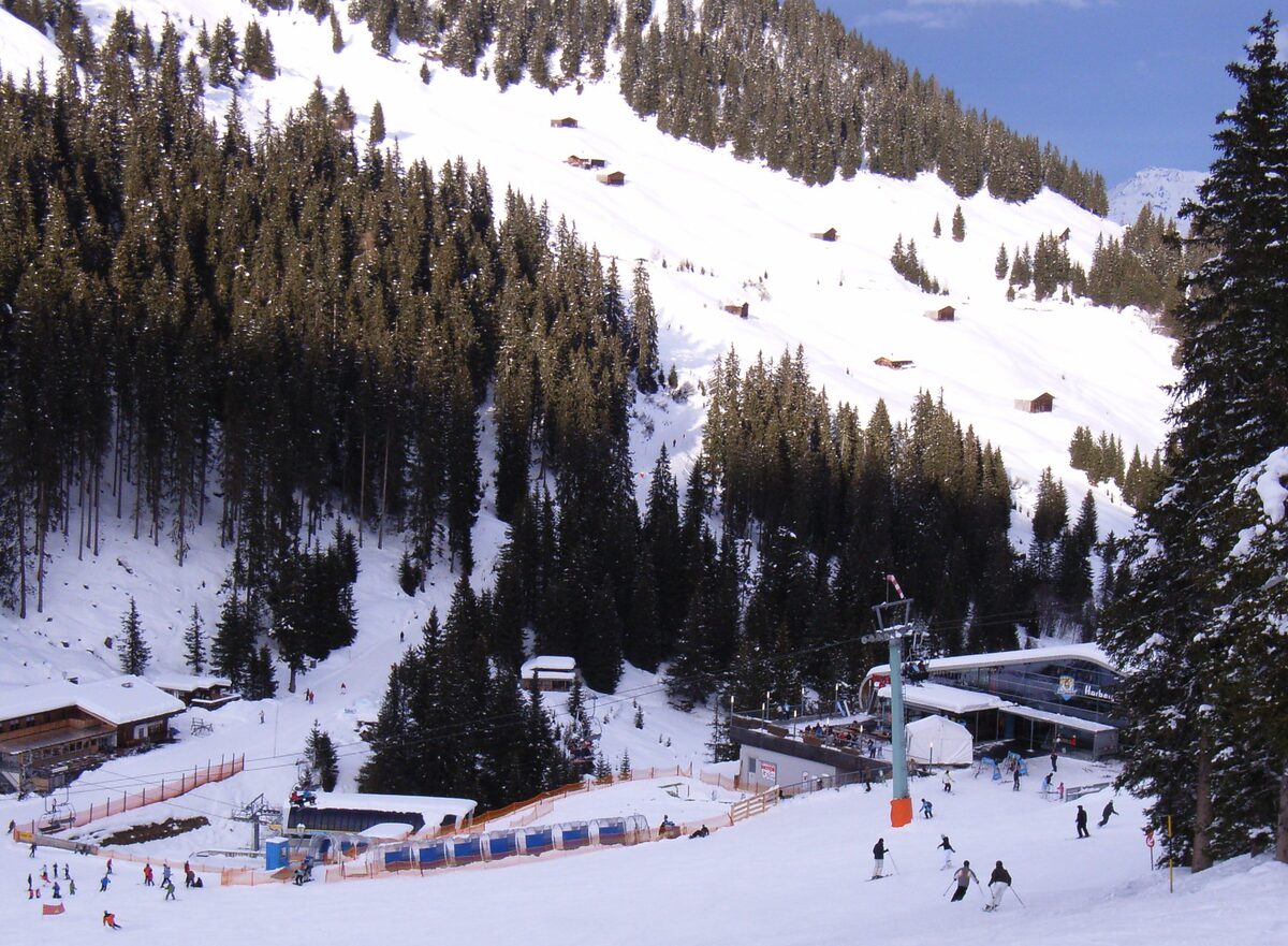 The mountain station of the Horbergbahn on a snowy slope, with the lift line and skiers around it