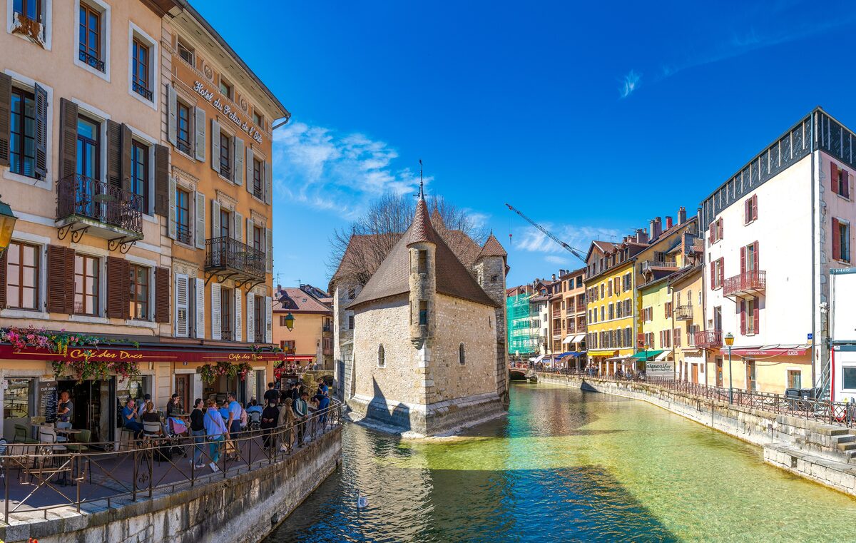 The Palais de l'Isle and the canal of Annecy in April sunshine, with old houses along the water