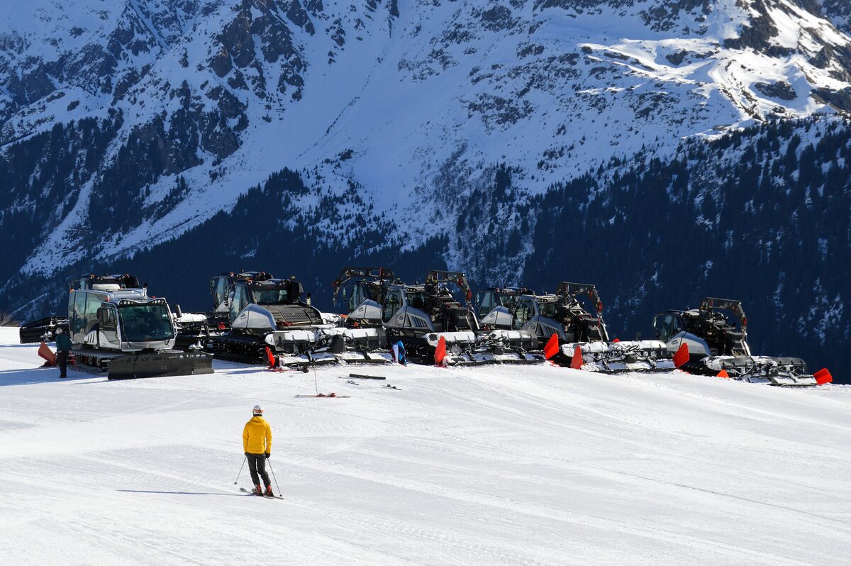 Snow groomers parked on the piste at Le Signal, with snowy mountains behind