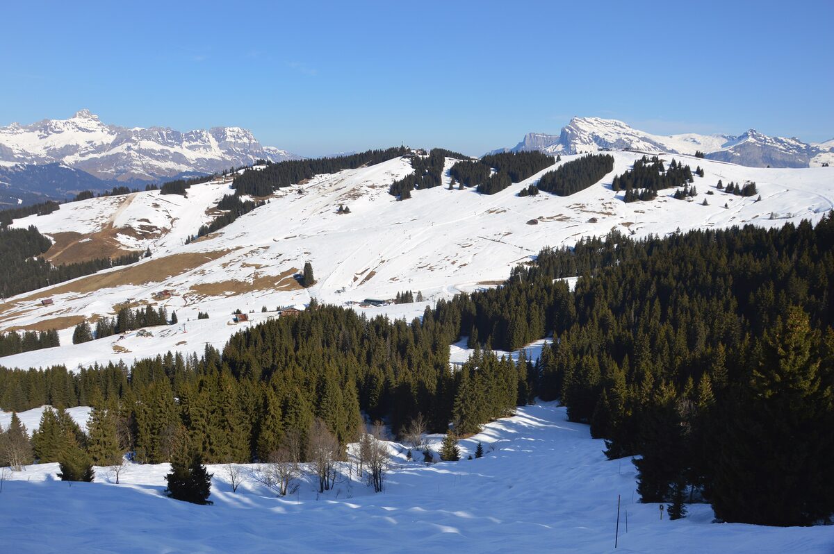 Snowy slopes and forest above Saint-Gervais, with the Mont d'Arbois ridge across the valley