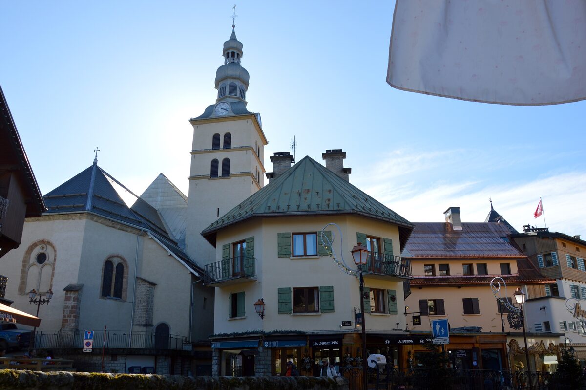 Saint-Jean-Baptiste church tower and village houses seen from the Quai du Prieuré under winter sun