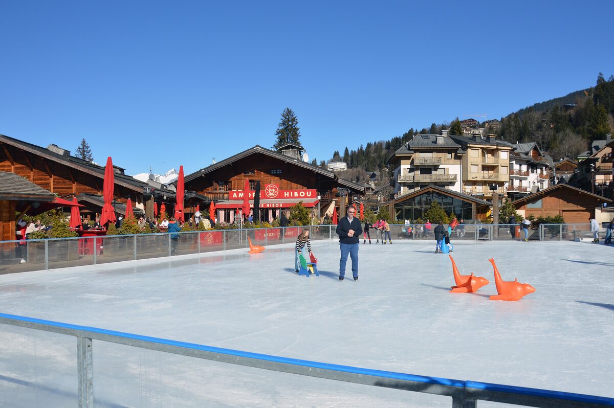 The ice rink on Place de la Résistance in the pedestrian center of Megève, with chalet restaurants and shops around it
