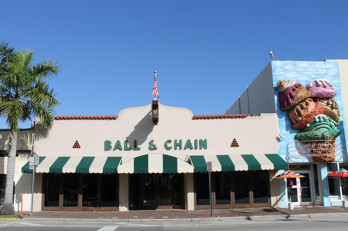 The cream facade of Ball & Chain on Calle Ocho, with its green striped awnings and a giant ice cream mural beside it