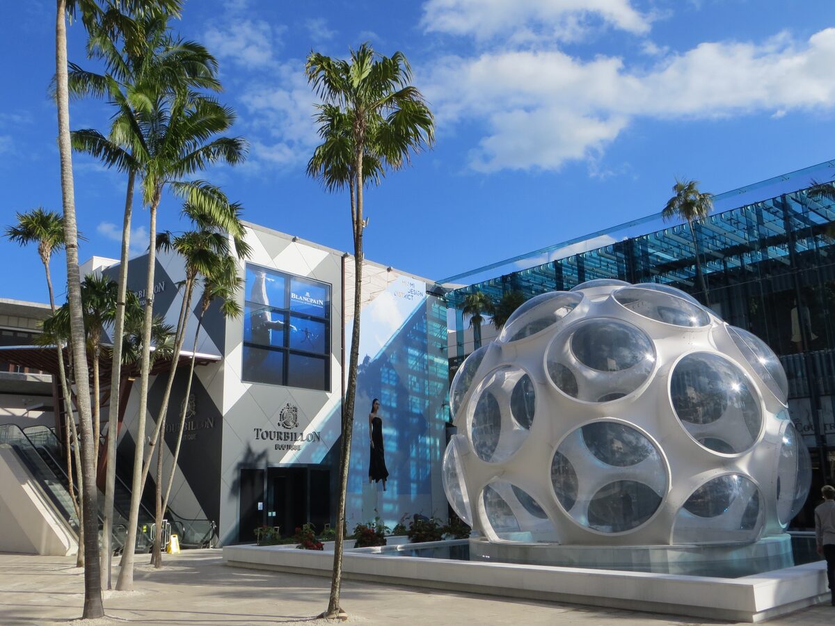 Buckminster Fuller's Fly's Eye Dome, a white geodesic sphere, in the Miami Design District with palms and glass buildings around it