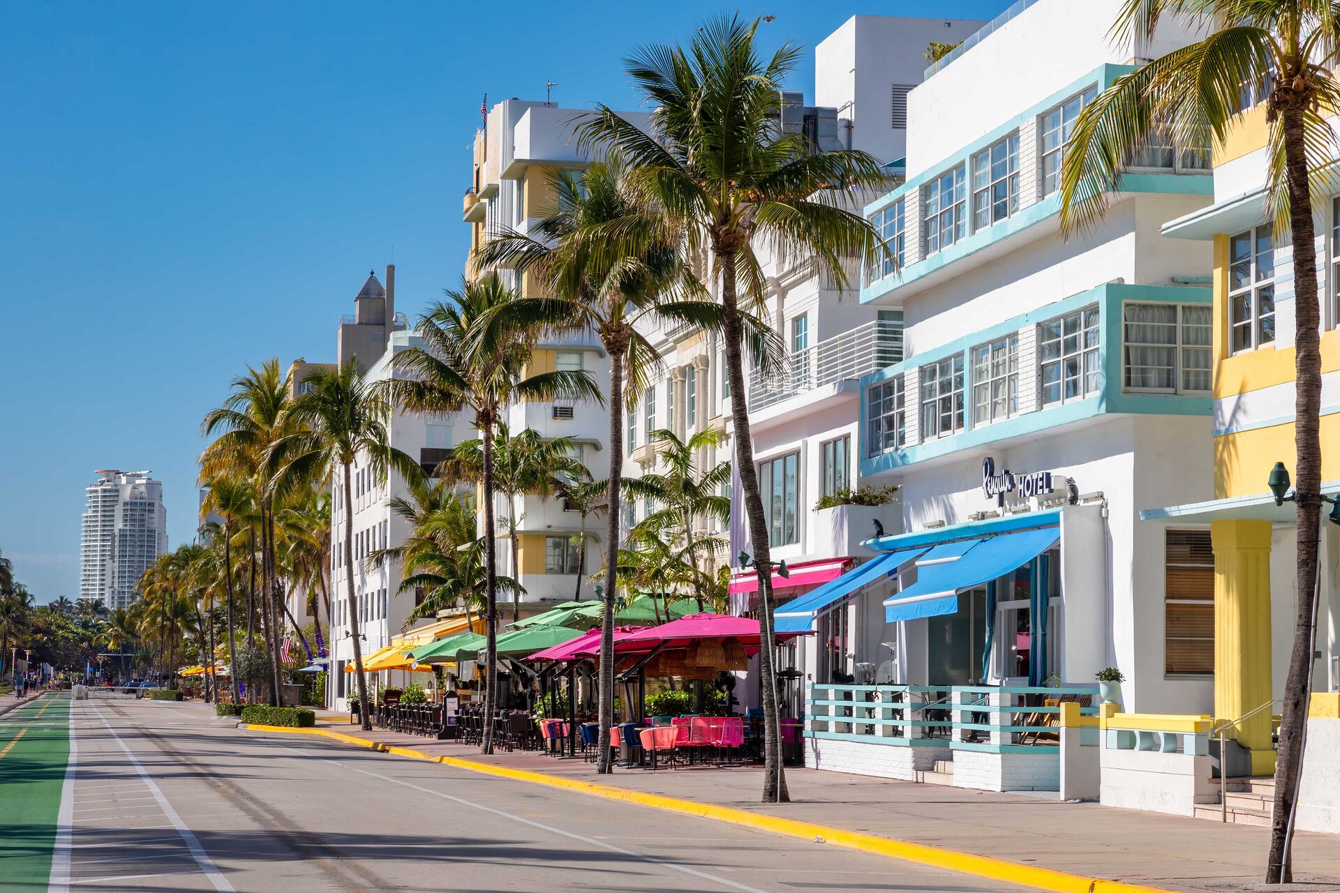 Pastel Art Deco hotels along Ocean Drive in South Beach, with palm trees and the beach beside the street