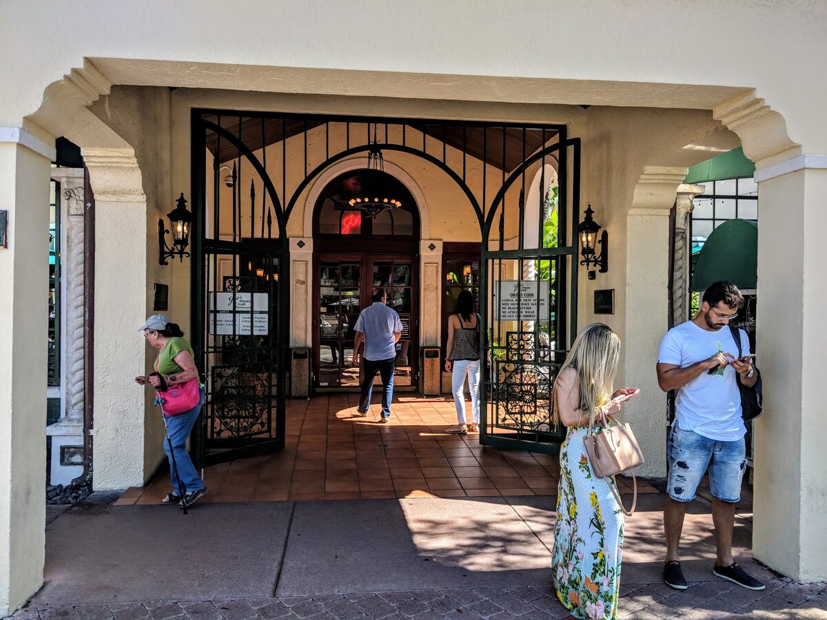 The arched entrance of Joe's Stone Crab restaurant in South Beach, with iron gates and a tiled forecourt